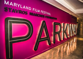 A wall that reads MARYLAND FILM FESTIVAL STAVROS NIARCHOS FOUNDATION PARKWAY in bright letters